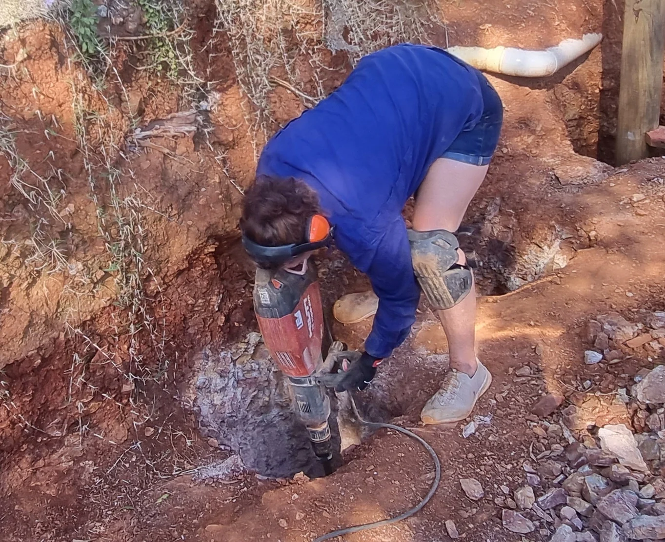 Stacey using a jackhammer during renovation work.